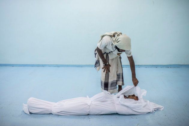 Al KHAWKHAH, YEMEN - SEPTEMBER 22: The body of a Yemeni fighter killed in Hodeidah is attended to by a friend at the morgue of a field hospital on September 22, 2018 in Al Khawkhah, Yemen. A coalition military campaign has moved west along Yemen's coast toward Hodeidah, where increasingly bloody battles have killed hundreds since June, putting the country's fragile food supply at risk. (Photo by Andrew Renneisen/Getty Images)