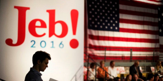 Campaign intern Jack Nalen hands out signs at Miami Dade College in Miami, Monday, June 15, 2015, before former Florida Gov. Jeb Bush is expected to formally join the race for president with a speech. (AP Photo/David Goldman)