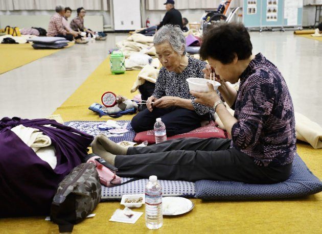 Residents from a quake-hit area eat their dinner at a shelter in Atsuma town, Hokkaido prefecture on September 7, 2018, a day after a hillside collapsed with the force of the 6.6-magnitude quake. - Japanese rescue workers with bulldozers and sniffer dogs scrabbled through the mud to find survivors from a landslide that buried houses after powerful quake, as the death toll rose to 18. (Photo by JIJI PRESS / JIJI PRESS / AFP) / Japan OUT (Photo credit should read JIJI PRESS/AFP/Getty Images)