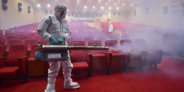 South Korean health officials fumigate a theater while wearing protective gear in Seoul on June 12, 2015. South Korea on June 12, reported four more cases of Middle East Respiratory Syndrome (MERS), bringing to 126 the total number of people diagnosed with the potentially deadly virus. AFP PHOTO / JUNG YEON-JE (Photo credit should read JUNG YEON-JE/AFP/Getty Images)