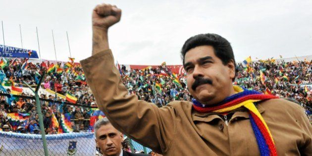 Venezuelan President Nicolas Maduro raises his fist as he arrives to a rally congregating thousands of representatives of regional social movements in Santa Cruz, Bolivia on June 14, 2014, where the G77+China Summit will take place. Leaders of developing nations plus China meet here Saturday to draft a global anti-poverty agenda at a summit that also showcases Latin America's burgeoning relationship with the Asian giant. AFP PHOTO/CRIS BOURONCLE (Photo credit should read CRIS BOURONCLE/AFP/Getty Images)