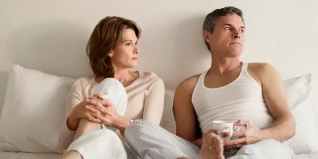 Couple looking serious on the bed