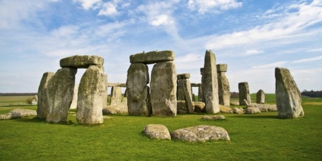 The world famous prehistoric landmark and UNESCO World Heritage Site on Salisbury Plain, Wiltshire, England. A beautiful blue sky with fluffy clouds provides copy space above while bright green grasses below grab the viewer's attention.