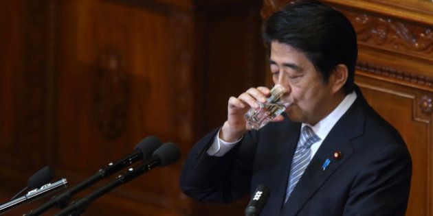 Shinzo Abe, Japan's prime minister, drinks a glass of water as he delivers a policy speech during an extraordinary session at the lower houses of the parliament in Tokyo, Japan, on Monday, Sept. 29, 2014. Abe said in his speech at the opening of the parliamentary session, he must carefully watch the effect on economy of sales-tax increase, fuel price rises and bad weather. Photographer: Tomohiro Ohsumi/Bloomberg via Getty Images