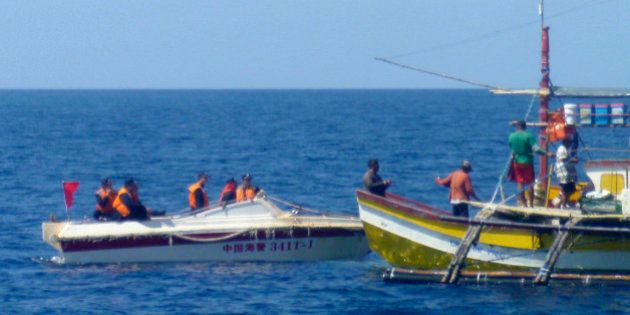 In this Feb. 27, 2015, photo, provided by Filipino fisherman Renato Etac, Chinese Coast Guard members approach Filipino fishermen near Scarborough Shoal in the South China Sea. An international tribunal has found that there is no legal basis for China's claiming rights to much of the South China Sea. The Permanent Court of Arbitration (PCA) issued its ruling Tuesday, July 12, 2016, in The Hague in response to an arbitration case brought by the Philippines against China regarding the South China Sea, saying that any historic rights to resources that China may have had were wiped out if they are incompatible with exclusive economic zones established under a U.N. treaty. (Renato Etac via AP)
