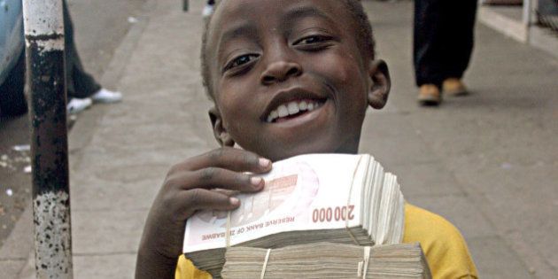 2008年2月19日火曜日、ハラレの路上で物乞いをするジンバブエドル札の束を手にポーズをとる子供たち。2008年2月21日木曜日、ジンバブエの公式インフレ率が10万％の壁を超え、世界で最も高い数値になったと中央統計局が発表した。