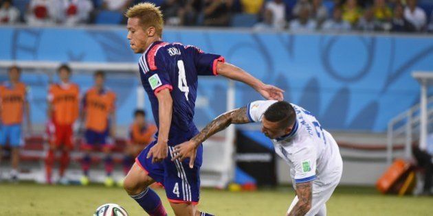 Japan's forward Keisuke Honda (L) and Greece's defender Jose Holebas (R) vie for the ball during a Group C football match between Japan and Greece at the Dunas Arena in Natal during the 2014 FIFA World Cup on June 19, 2014. AFP PHOTO / FABRICE COFFRINI (Photo credit should read FABRICE COFFRINI/AFP/Getty Images)