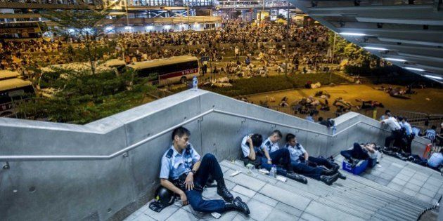 Policemen rest following pro-democracy protests in Hong Kong on September 29, 2014. Police fired tear gas as tens of thousands of pro-democracy demonstrators brought parts of central Hong Kong to a standstill in a dramatic escalation of protests that have gripped the semi-autonomous Chinese city for days. AFP PHOTO / XAUME OLLEROS (Photo credit should read XAUME OLLEROS/AFP/Getty Images)
