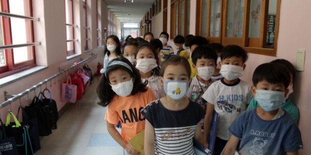 SEOUL, SOUTH KOREA - JUNE 09: Elementary school students wear masks as a precaution against the MERS virus as they wait for a lesson to start at Midong Elementary School on June 9, 2015 in Seoul, South Korea. South Korea has reported eight deaths related to the virus with 2,500 people quarantined and 1,800 schools closed as of June 9, 2015. (Photo by Chung Sung-Jun/Getty Images)