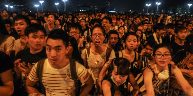 HONG KONG - OCTOBER 2: Pro-democracy protesters chant slogans outside of Hong Kong's Chief Executive C.Y. Leung's office on October 2, 2014. Protesters continued to block main transport routes, after a peaceful night of demonstrations in the Chinese territory. The protests followed a decision last month by China's top legislative body to restrict the nominations for chief executive in 2017. The candidate who wins the popular vote would have to be formally appointed by the central government before taking office. (Photo by Thomas Campean/Anadolu Agency/Getty Images)