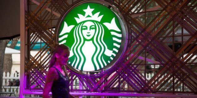 A woman walks by the logo of American coffee company and coffeehouse chain Starbucks coffee on the eve of the official opening of the first Starbucks shop in South Africa and Sub Saharian africa on April 20, 2016 in Johannesburg. / AFP / GIANLUIGI GUERCIA (Photo credit should read GIANLUIGI GUERCIA/AFP/Getty Images)