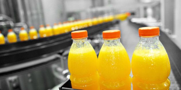 Orange juice bottles on factory assembly line