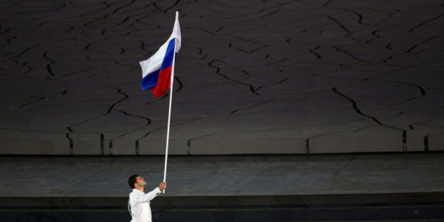 BAKU, AZERBAIJAN - JUNE 12: flag bearer and wrestler, Khadzhimurat Gatcalov of Russia leads his team into the stadium during the Opening Ceremony for the Baku 2015 European Games at the Olympic Stadium on June 12, 2015 in Baku, Azerbaijan. (Photo by Paul Gilham/Getty Images for BEGOC)