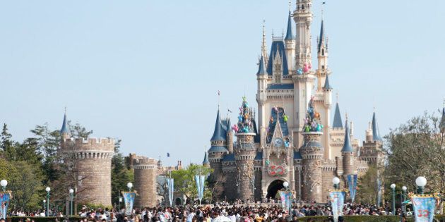 Visitors walk past the Cinderella Castle during 30th anniversary celebrations of Tokyo Disneyland, operated by Oriental Land Co., at the amusement park in Urayasu City, Chiba Prefecture, Japan, on Monday, April 15, 2013. Oriental Land in 1979 entered into a formal agreement with Walt Disney Co. to license and operate the theme park, which opened in 1983, according to its website. Photographer: Kiyoshi Ota/Bloomberg via Getty Images