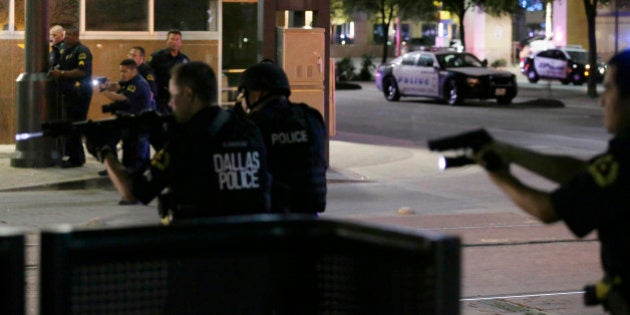 Dallas police move to detain a driver after several police officers were shot in downtown Dallas, Thursday, July 7, 2016. At least two snipers opened fire on police officers during protests Thursday night; some of the officers were killed, police said. (AP Photo/LM Otero)