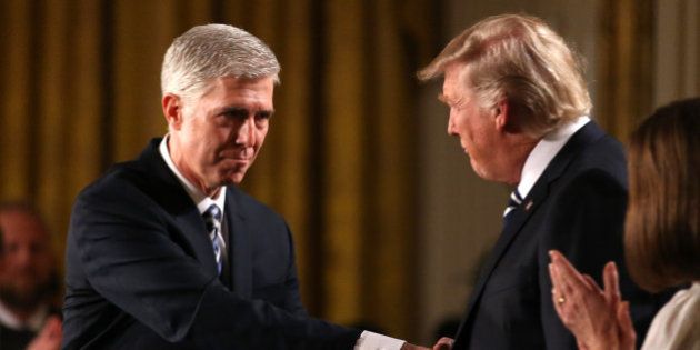 Judge Neil Gorsuch (L) shakes hands with U.S. President Donald Trump as Gorsuch's wife Louise (R) applauds after President Trump nominated Gorsuch to be an associate justice of the U.S. Supreme Court at the White House in Washington, D.C., U.S., January 31, 2017. REUTERS/Carlos Barria TPX IMAGES OF THE DAY