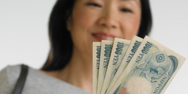 Low angle view of Asian woman holding Japanese money