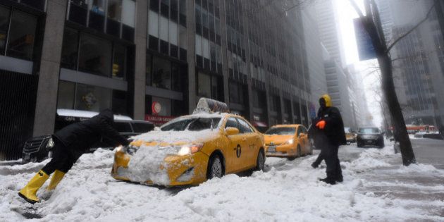 Men try to push a cab stuck in the snow on a street in New York on March 14, 2017.Winter Storm Stella dumped sleet and snow across the northeastern United States on Tuesday but spared New York from the worst after authorities cancelled thousands of flights and shut schools. Blizzard warnings were in effect in parts of Connecticut, Massachusetts and upstate New York, but were lifted for New York City, the US financial capital home to 8.4 million residents, where snow turned to sleet, hail and rain. / AFP PHOTO / ERIC BARADAT (Photo credit should read ERIC BARADAT/AFP/Getty Images)