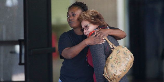 Two women embrace at a community center where family members are gathering to pick up survivors after a shooting rampage that killed multiple people and wounded others at a social services center in San Bernardino, Calif., Wednesday, Dec. 2, 2015. (AP Photo/Jae C. Hong)