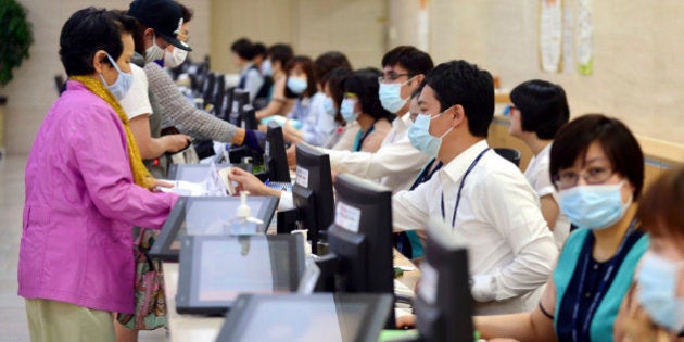 Hospital workers, right, wear masks as a precaution against Middle East Respiratory Syndrome virus as they talk with visitors at Chonnam University Hospital in Gwangju, South Korea, Monday, June 8, 2015. South Korea on Monday reported its sixth death from MERS as authorities were bolstering measures to stem the spread of the virus that has left dozens of people infected. (Yun Hyung-geun/Newsis via AP) KOREA OUT