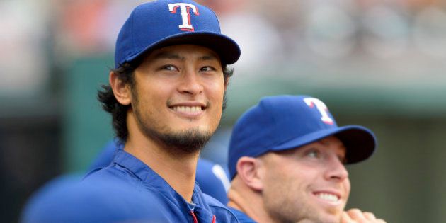 CLEVELAND, OH - AUGUST 1: Pitcher Yu Darvish #11 of the Texas Rangers watches the game from the dugout during the second inning against the Cleveland Indians at Progressive Field on August 1, 2014 in Cleveland, Ohio. (Photo by Jason Miller/Getty Images)