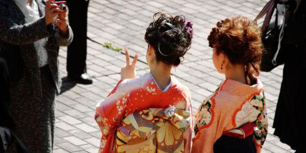 Two Japanese girls on their university graduation day. Thay are dressed to kimonos and hakama trousers.
