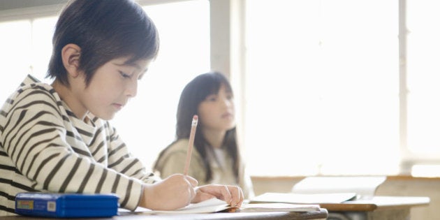 Children (7-9) studying in school classroom