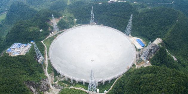 UNSPECIFIED, CHINA - JULY 03: Workers lift the last panel to install into the center of a Five-hundred-meter Aperture Spherical Telescope (FAST) on July 3, 2016, China. The dish-like telescope, as large as 30 football fields, costing 1.2 billion yuan (about 180 million USD), will be used for reasearch and further adjustment according to China Daily. (Photo by VCG/VCG via Getty Images)