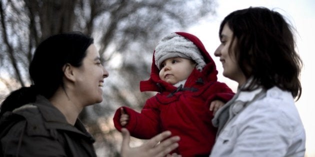 Same sex couple Olga Miranda (R) and Matilde Custodio (L) hold their daughter Carolina during a walk in the park in Lisbon on February 23, 2014. Matilde Custodio, 35 years old, call center operator and her girlfriend Olga Miranda, 31 years old, manager of a gourmet company have lived together for 10 years before deciding to have a child by artificial insemination. In Portugal the law allowing gay marriage, passed in January 2010, specifically excludes the right to adopt for homosexual couples making Olga's adoption of Carolina (14 months) impossible. AFP PHOTO/ PATRICIA DE MELO MOREIRA (Photo credit should read PATRICIA DE MELO MOREIRA/AFP/Getty Images)