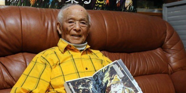 To go with Japan-history-WWII-anniversary-soldiers,FEATURE by Kyoko HASEGAWAThis picture taken on May 12, 2015 shows Japanese 93-year-old comic artist Shigeru Mizuki displaying his graphic novel 'Complete Collection of Shigeru Mizuki's Manga Works - Showa: A History of Japan' at his studio in Tokyo. Mizuki uses manga, graphic novels, to spread his message of the horror of war. In his works, including the award-winning 'Onward Towards Our Noble Deaths', Mizuki describes the lot of enlisted soldiers sent to New Britain island, now part of Papua New Guinea. In an essay with a hundred of sketches he drew as 'a war chronicle', Mizuki tells of how he was the only survivor when his unit came under attack in 1944. AFP PHOTO / Yoshikazu TSUNO (Photo credit should read YOSHIKAZU TSUNO/AFP/Getty Images)