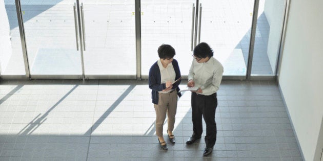 Businessperson talking in entrance hall of office