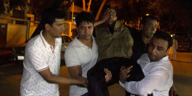 People carry an injured man near the Holey Artisan Bakery restaurant during an attack by unidentified gunmen in Dhaka's high-security diplomatic district on July 2, 2016.Gunmen stormed a crowded restaurant popular with foreigners in the Bangladeshi capital on July 1 night, apparently taking diners hostage and sparking a firefight with police in which at least two officers were killed, police and witnesses said. / AFP / STR (Photo credit should read STR/AFP/Getty Images)