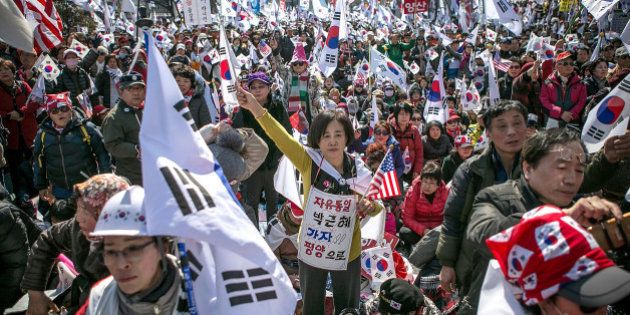 SEOUL, SOUTH KOREA - MARCH 10: Supporters of President Park Geun-hye react emotionally as the Constitutional Court had ruled the impeachment near the court on March 10, 2017 in Seoul, South Korea. Park will be permanently removed from the South Korean office and the nation will need to hold a presidential election within 60 days. Park had been impeached by parliament in December for allegedly letting her confidante Choi Soon-sil involved in state affairs and colluded to take bribes of millions of dollars from South Korean conglomerates. (Photo by Jean Chung/Getty Images)