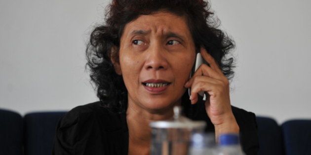 The owner of Indonesian scheduled and charter airline Susi Air, Susi Pudjiastuti, speaks over the phone in Pangandaran, West Java, on September 10, 2011. A Susi Air Cessna Grand Caravan aircraft with one Australian and one Slovak pilot on board crashed in the country's remote Papua region, a company spokesman said, with both men feared dead. AFP PHOTO / Bay ISMOYO (Photo credit should read BAY ISMOYO/AFP/Getty Images)