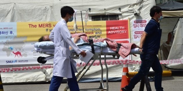 South Korean hospital workers carry transport a man in front of a quarantine tent for suspected MERS cases at the Seoul National University Hospital in Seoul on June 2, 2015. South Korea's health ministry confirmed that two people have died from Middle East Respiratory Syndrome (MERS), the country's first fatalities from the virus.AFP PHOTO / JUNG YEON-JE (Photo credit should read JUNG YEON-JE/AFP/Getty Images)