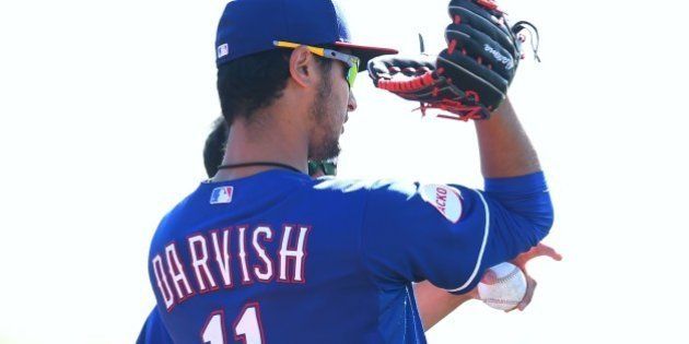 SURPRISE, AZ - MARCH 08: Yu Darvish #11 of the Texas Rangers talks with teammates during the spring training at the Surprise Stadium on March 8, 2015 in Surprise, Arizona. (Photo by Masterpress/Getty Images)