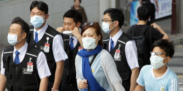 SEOUL, SOUTH KOREA - JUNE 02: People wear masks as a precaution against the MERS virus on June 2, 2015 in Seoul, South Korea. The Ministry of Health and Welfare of South Korea confirmed two deaths from Middle East Respiratory Syndrome (MERS) on June 2, 2015. It reported six new cases of MERS, raising the number of confirmed local patients to 25. The first case was confirmed on May 20. (Photo by Chung Sung-Jun/Getty Images)