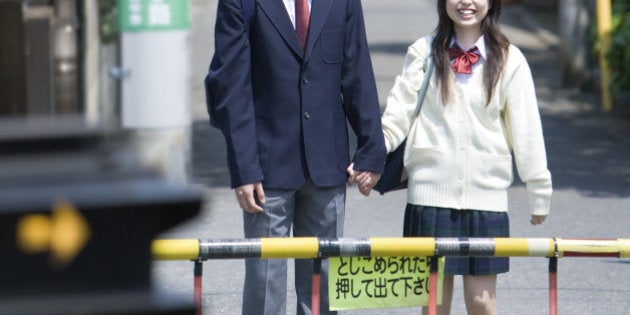 High scool student waiting for the train to pass at rail crossing