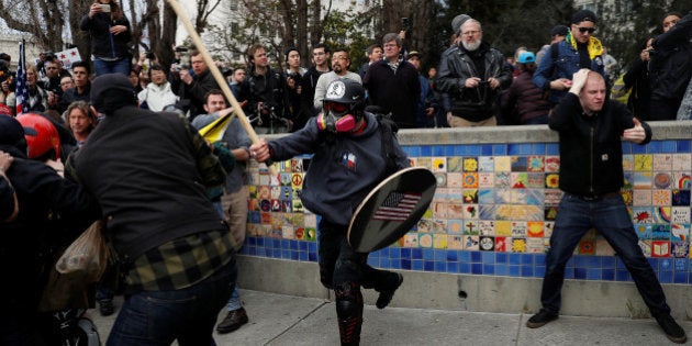 A demonstrator in support of U.S. President Donald Trump swings a stick towards a group of counter-protesters during a