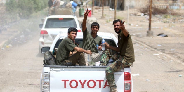 Iraqi government forces flash the 'V' for victory sign in Fallujah, 50 kilometres (30 miles) from the Iraqi capital Baghdad, after forces retook the embattled city from the Islamic State group on June 26, 2016.Iraqi Prime Minister Haider al-Abadi urged all Iraqis to celebrate the recapture of Fallujah by the security forces and vowed the national flag would be raised in Mosul soon. While the battle has been won, Iraq still faces a major humanitarian crisis in its aftermath, with tens of thousands of people who fled the fighting desperately in need of assistance in the searing summer heat. / AFP / HAIDAR MOHAMMED ALI (Photo credit should read HAIDAR MOHAMMED ALI/AFP/Getty Images)