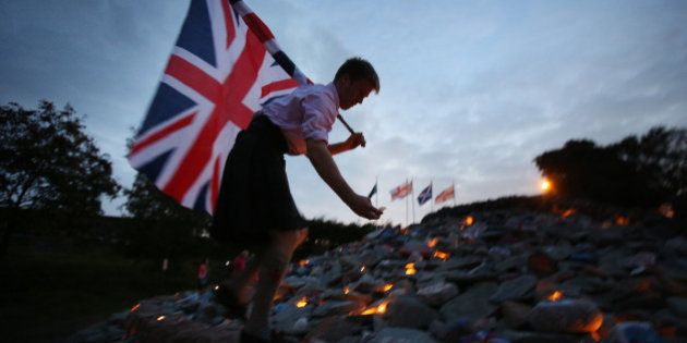 GRETNA GREEN, SCOTLAND - SEPTEMBER 16: Better Together campaigner Monty Lewis holds a Union flag as he lights candles on a cairn near the Scotland England border on September 16, 2014 in Gretna, Scotland. Yes and No supporters are campaigning in the last two days of the referendum to decide if Scotland will become an indpendent country. (Photo by Peter Macdiarmid/Getty Images)