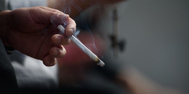 A man smokes in a designated smoking area in Tokyo, Japan, on Wednesday, Sept. 30, 2015. Japan Tobacco Inc. fell to the lowest in six months after agreeing to pay about $5 billion for the international rights to Reynolds American Inc's Natural American Spirit division. Photographer: Akio Kon/Bloomberg via Getty Images