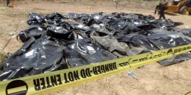 Body-bags containing the remains of people believed to have been slain by jihadists of the Islamic State (IS) group lie on the ground at the Speicher camp in the Iraqi city of Tikrit, on April 12, 2015. The Islamic State (IS) jihadist group executed hundreds of mostly Shiite recruits last June in what is known as the Speicher massacre, named for the military base near which they were captured. Thirteen grave sites have been found -- 10 in the palace complex and three outside, Haider Majid, an employee of Prime Minister Haider al-Abadi's office working on the Speicher issue, said. AFP PHOTO / AHMAD AL-RUBAYE (Photo credit should read AHMAD AL-RUBAYE/AFP/Getty Images)