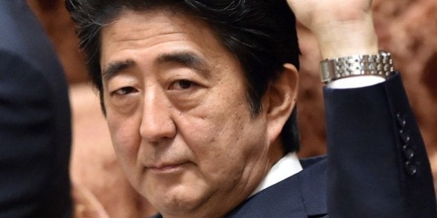 Japanese Prime Minister Shinzo Abe raises his hand to answer questions during the Lower House's ad hoc committee session to expand the scope of Japan's self defence force overseas operations at the National Diet in Tokyo on May 27, 2015. Japanese parliament began deliberations on the bills bolstering the role and scope of the military, as the pacifist country redefines its position in the increasingly roiled Asia-Pacific region. AFP PHOTO / Yoshikazu TSUNO (Photo credit should read YOSHIKAZU TSUNO/AFP/Getty Images)