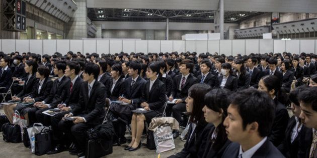 TOKYO, JAPAN - MARCH 08: (EDITORIAL USE ONLY) College students listen to a company information session at the Mynavi Shushoku MEGA EXPO at the Tokyo Big Sight on March 8, 2015 in Tokyo, Japan. 70,000 job-seeking students are expected to attend the two-day career fair with 1229 companies participating. Under new rules starting this academic year, companies are allowed to conduct recruiting activities from March 1 onward, rather than December so that third-year university students can concentrate on their studies. (Photo by Chris McGrath/Getty Images)