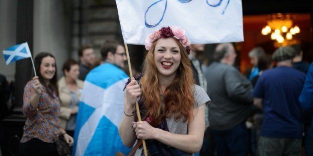 'Yes' campaign supporter waves a flag outside Usher Hall ahead of the 'A Night for Scotland' concert in Edinburgh, Scotland on September 14, 2014. Campaigners for and against Scottish independence raced to win over undecided voters ahead of Thursday's historic referendum, as religious leaders prayed for harmony and music fans gathered for a separatist concert. The Church of Scotland's moderator John Chalmers called for Scots to 'live in harmony with one another' whatever the result and hailed the run-up to the independence vote as 'a wonderful democratic concerto'. AFP PHOTO/LEON NEAL (Photo credit should read LEON NEAL/AFP/Getty Images)
