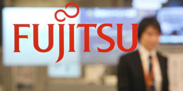 JAPAN - DECEMBER 04: An employee walks behind the logo for Fujitsu Ltd. at the company's offices in Tokyo, Japan, on Tuesday, Dec. 4, 2007. Fujitsu Ltd., Japan's biggest computer-services provider, will set up a company in Taiwan to develop WiMax software as the island prepares to start services based on the high-speed wireless technology. (Photo by Tomohiro Ohsumi/Bloomberg via Getty Images)