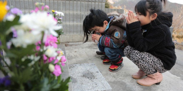 OTSUCHI, JAPAN - MARCH 09: (L-R) Miyu, Ryoga and Mahiro Abe offer prayer to their grandmother and grandfather, which lost their lives in the tsunami three years ago, at Kouganji Temple on March 9, 2014 in Otsuchi, Iwate, Japan. On March 11 Japan commemorates the third anniversary of the magnitude 9.0 earthquake and tsunami that claimed more than 18,000 lives, and subsequent nuclear disaster at the Fukushima Daiichi Nuclear Power Plant. (Photo by Yuriko Nakao/Getty Images)