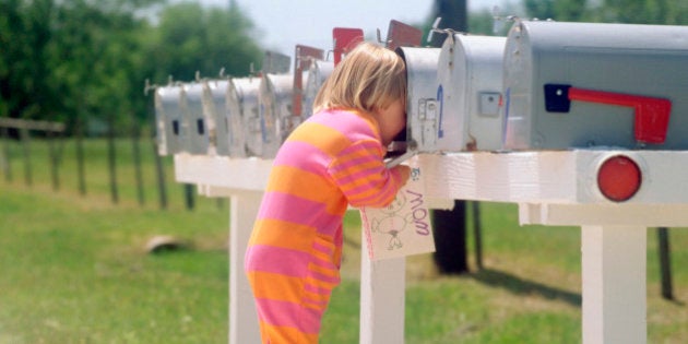 Girl standing on brother's back and peering into mailbox