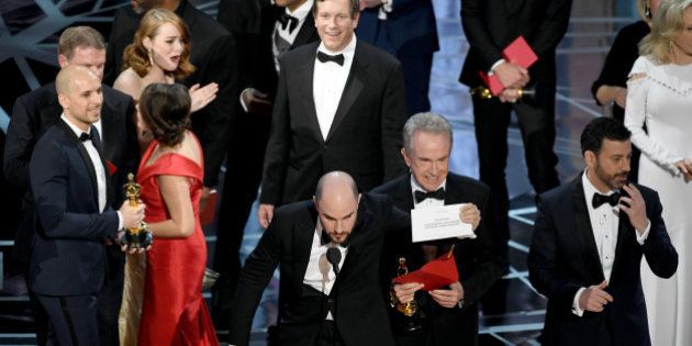 HOLLYWOOD, CA - FEBRUARY 26: (L-R) 'La La Land' producer Jordan Horowitz holds up the winner card reading actual Best Picture winner 'Moonlight' with actor Warren Beatty and host Jimmy Kimmel onstage during the 89th Annual Academy Awards at Hollywood & Highland Center on February 26, 2017 in Hollywood, California. (Photo by Kevin Winter/Getty Images)